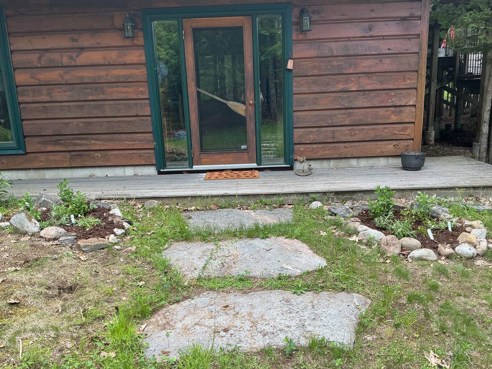 Both cottage entrance beds flanking the front door, freshly planted and mulched