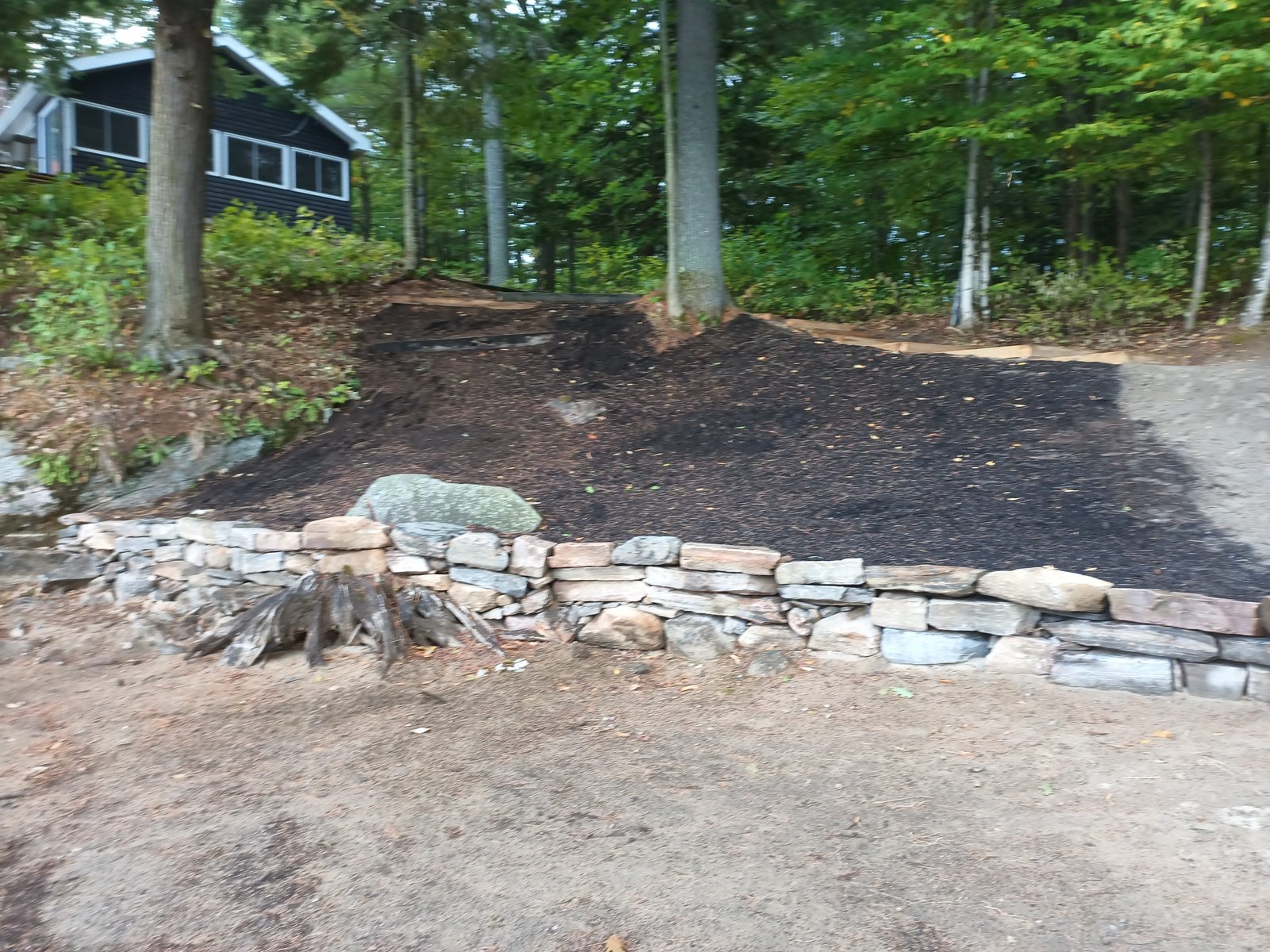 Main planting area from the stone wall — cottage above, ready for 714 plants
